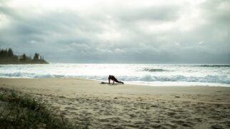 Surfista faz aquecimento na praia com mudança no tempo se aproximando ao fundo