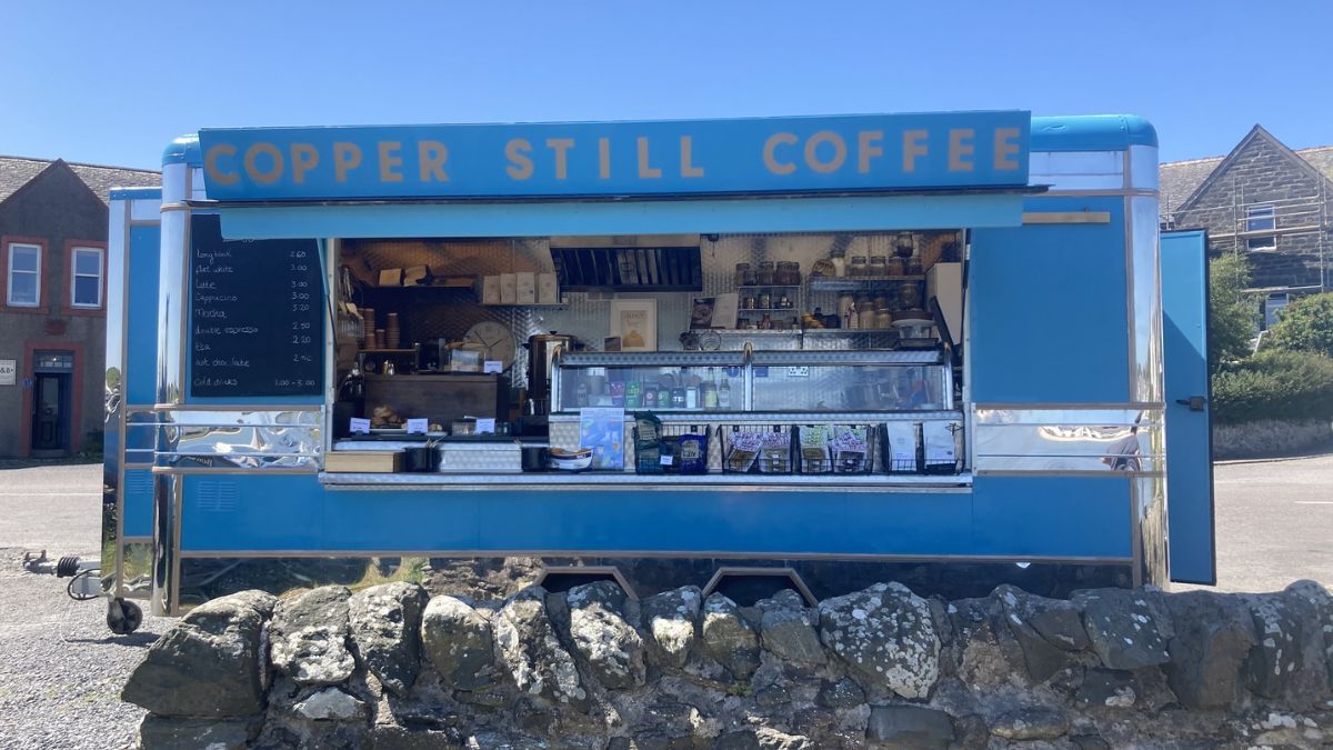Copper Still Coffee Ponto de parada popular em Port Ellen, o trailer azul serve cafés artesanais e bolos típicos escoceses/ Reprodução Facebook/Copper Still Coffee