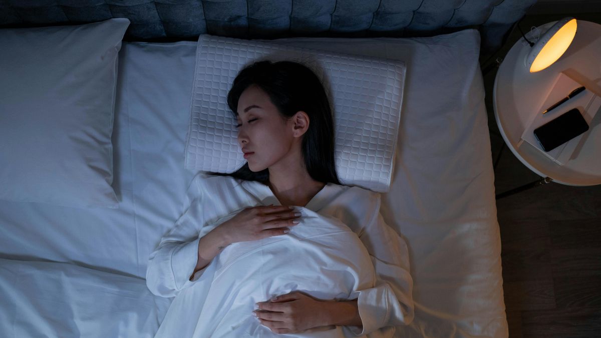 Dormir de costas com um travesseiro sob os joelhos também pode ser benéfico/ Pexels