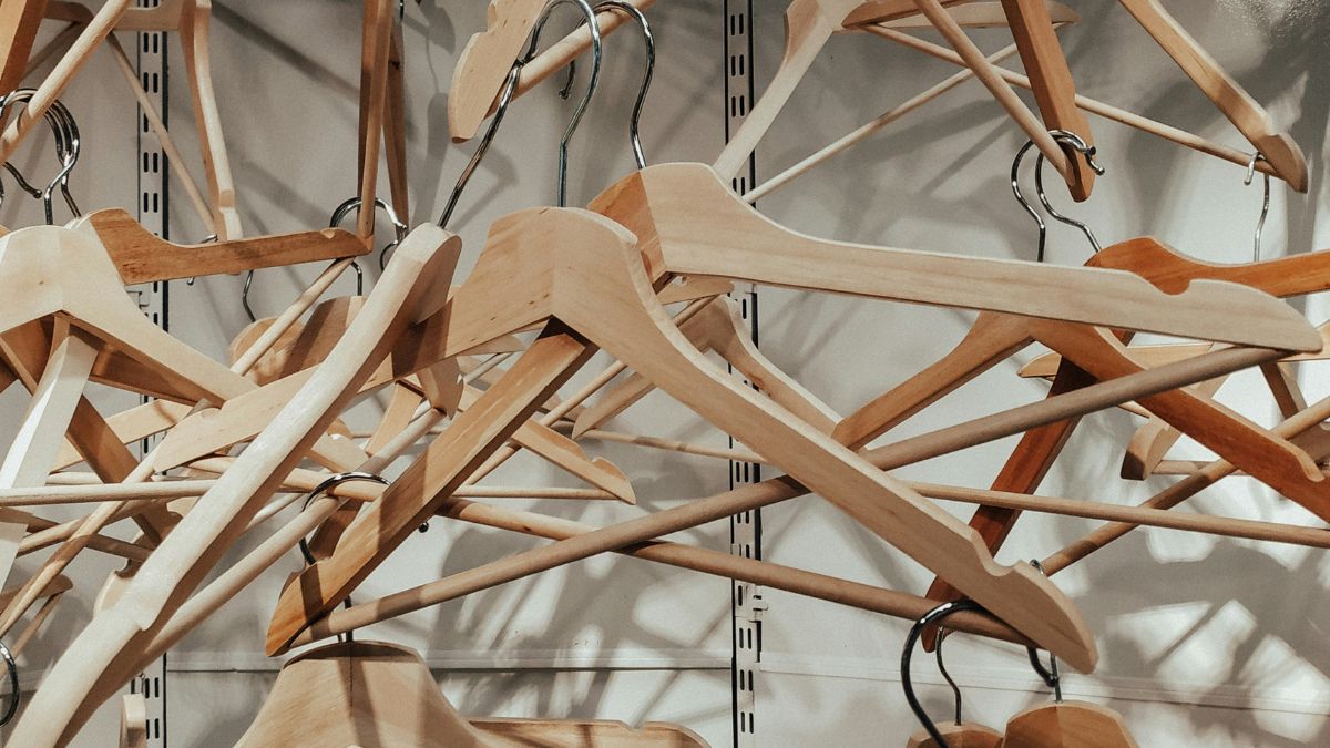 Ao contrário dos modelos de metal ou plástico, os cabides de madeira oferecem uma base durável e uma estética natural que se integra facilmente a diferentes estilos de decoração/Unsplash