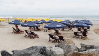Espaço oferece espreguiçadeiras sob guarda-sóis personalizados, criando uma atmosfera mais confortável e elegante