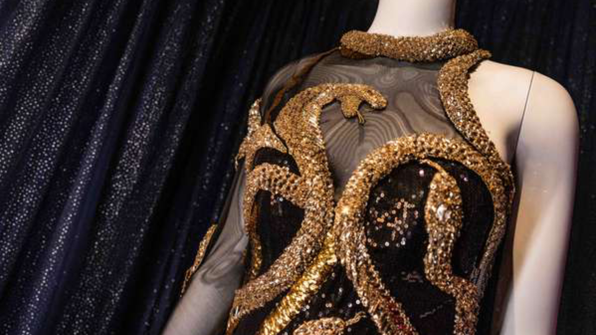 O icônico body preto assimétrico de Roberto Cavalli, adornado com serpentes douradas / Divulgação/Disney