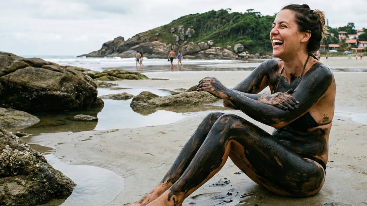 O tradicional banho de lama negra em Peruíbe, no litoral sul de SP