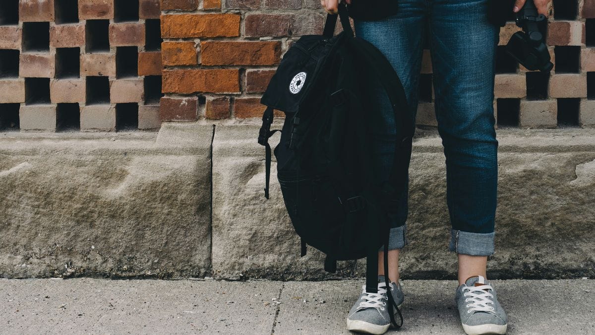 Carregar a mochila em apenas um ombro ou com ajuste inadequado aumenta o risco de desequilíbrio postural e lesões musculares. Unsplash/Scott Webb