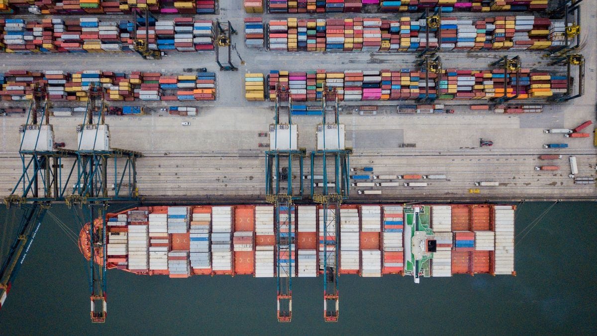 Vista aérea do Porto de Santos no início das operações, com navios atracados e guindastes em atividade no estuário da Baixada Santista