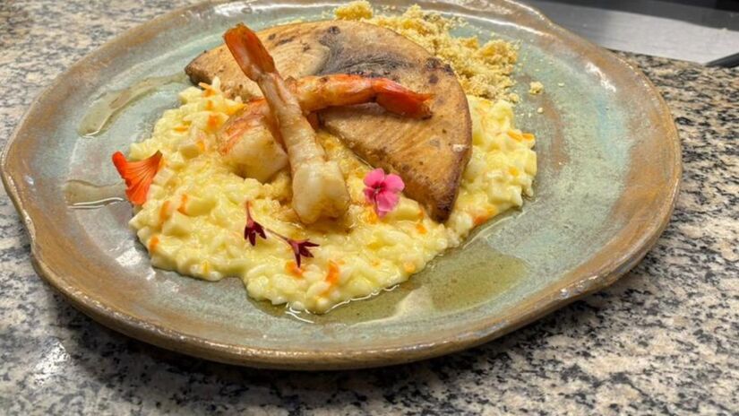 O prato combina o peixe grelhado com acompanhamentos clássicos e ingredientes regionais, unindo simplicidade, sabor e identidade cultural.