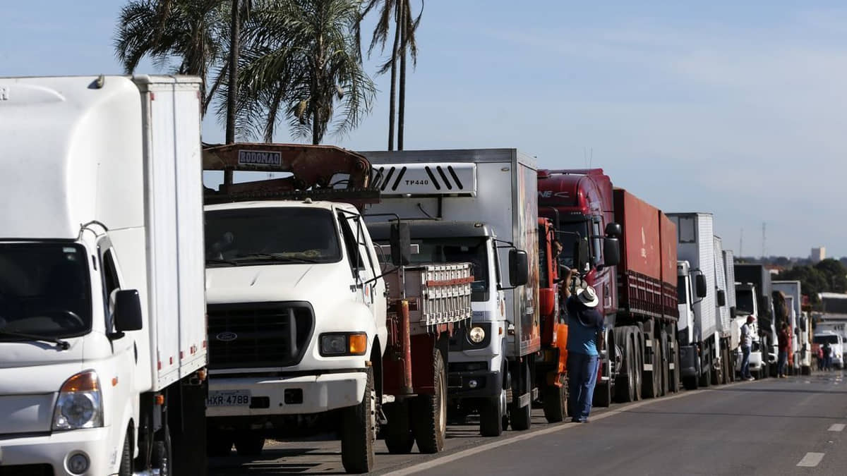 Caminhoneiros parados em fila em rodovia no Brasil