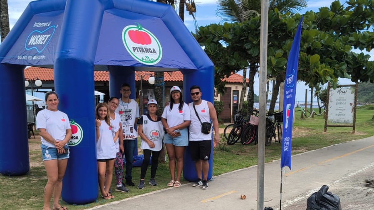 Voluntários recolhem diversos lixos jogados na areia da praia, em Itanhaém