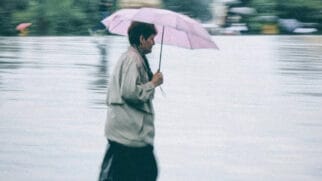 Mulher anda com seu guarda-chuva após virada no tempo causada por frente fria