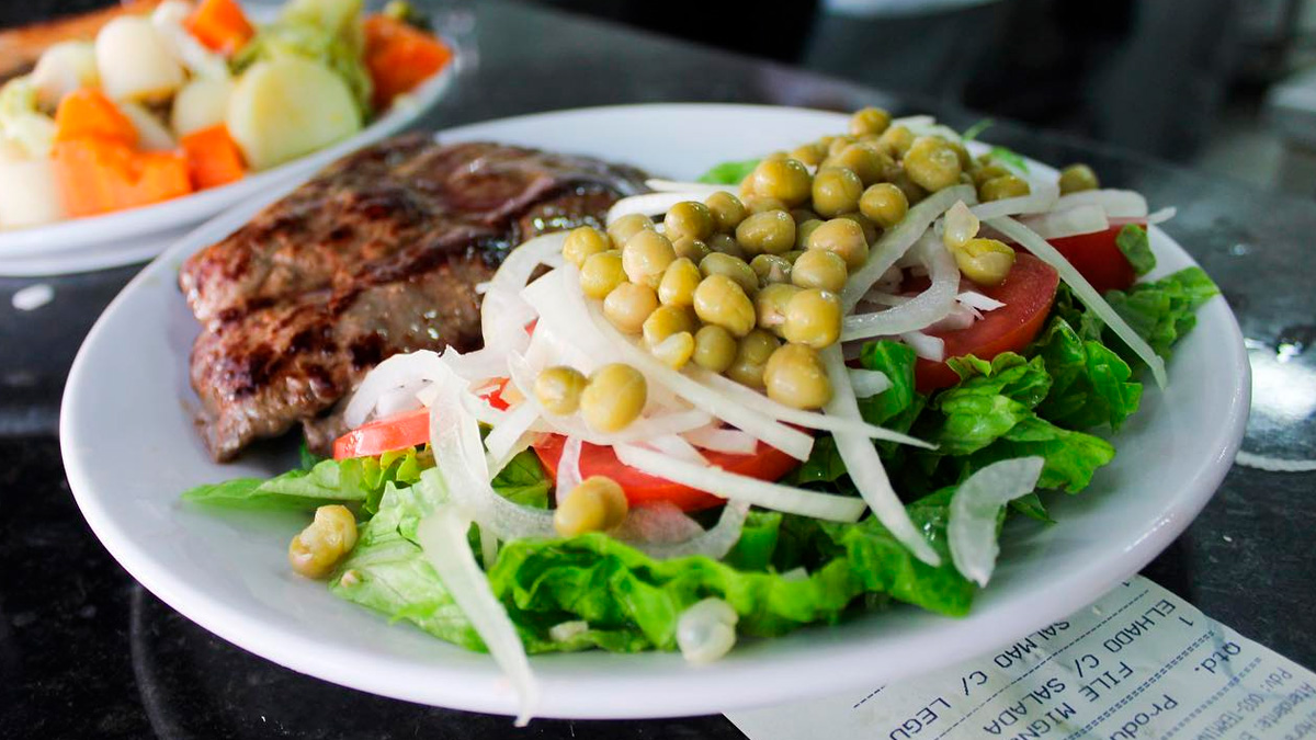Geralmente, a refeição inclui arroz, feijão, batata frita, uma proteína e salada, mas pode variar conforme a região do país.
